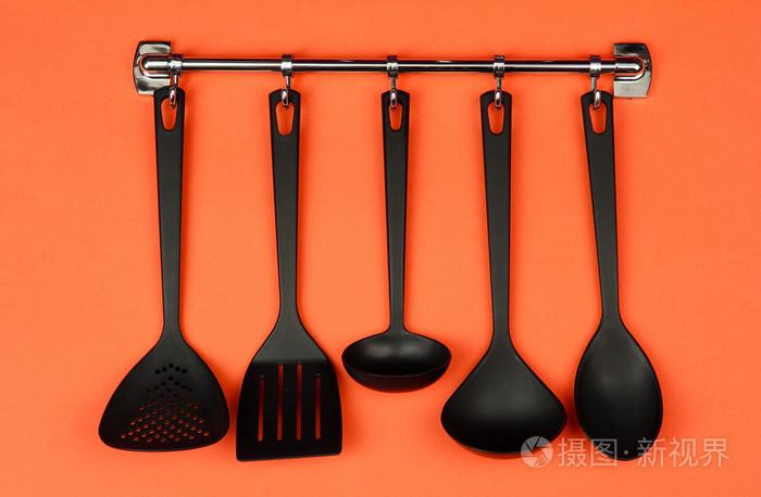 关于银钩,橙色背景上的黑色厨房用具照片-正版商用图片1d8cxy-摄图新